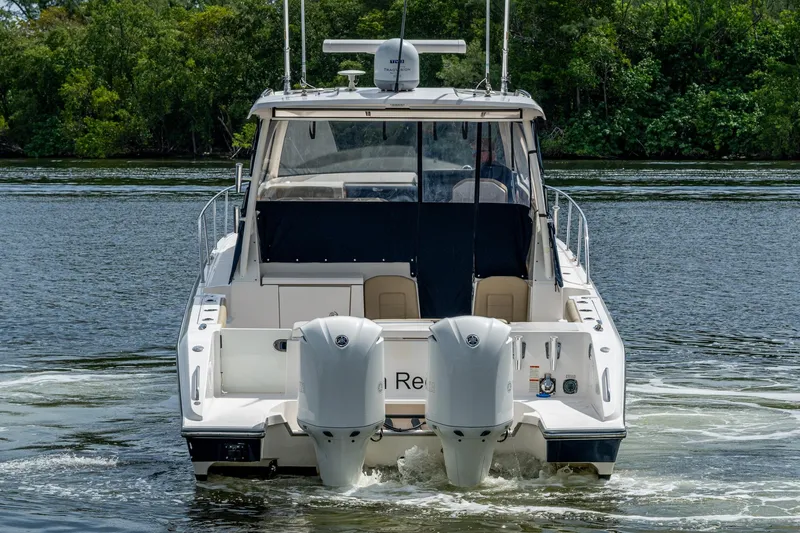 Slide: The Image of Rear view of a Pursuit boat with dual outboard motors on a calm river. - 6