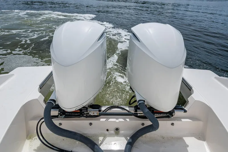 Slide: The Image of Twin outboard motors on a Pursuit boat navigating through water. - 64