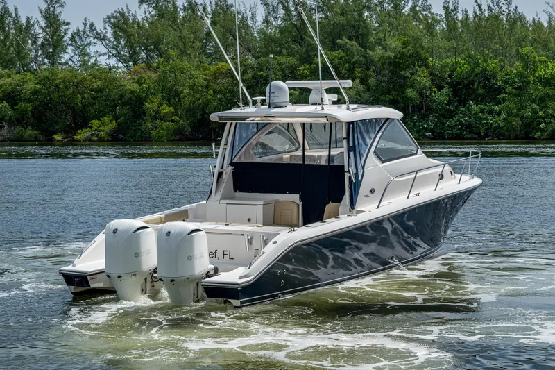Slide: The Image of Luxury Pursuit boat cruising on a serene waterway, surrounded by lush greenery. - 7