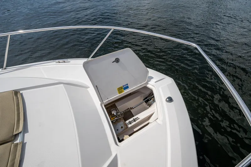 Slide: The Image of Open anchor compartment on Pursuit boat, with railing and water view. - 75