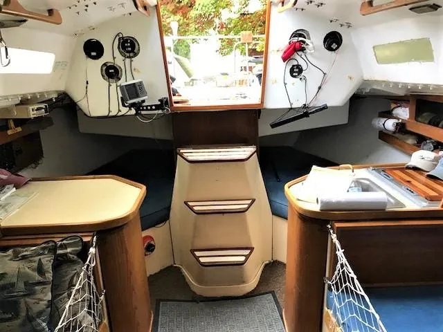 Slide: The Image of Interior of a 1979 J Boats J 30 sailboat, featuring navigation equipment and cozy seating. - 11