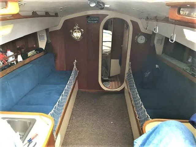 Slide: The Image of 1979 J Boats J 30 interior with blue seating, wood accents, and nautical decor. - 8