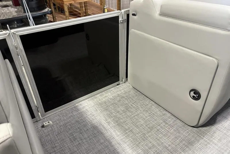 Slide: The Image of 2026 Sun Tracker PARTY BARGE® 20 DLX interior with open storage compartment and gray flooring. - 14