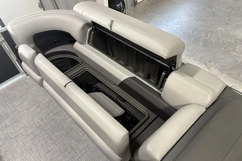Slide: The Image of 2026 Sun Tracker PARTY BARGE® 20 DLX interior with open storage compartments and gray seating. - 2