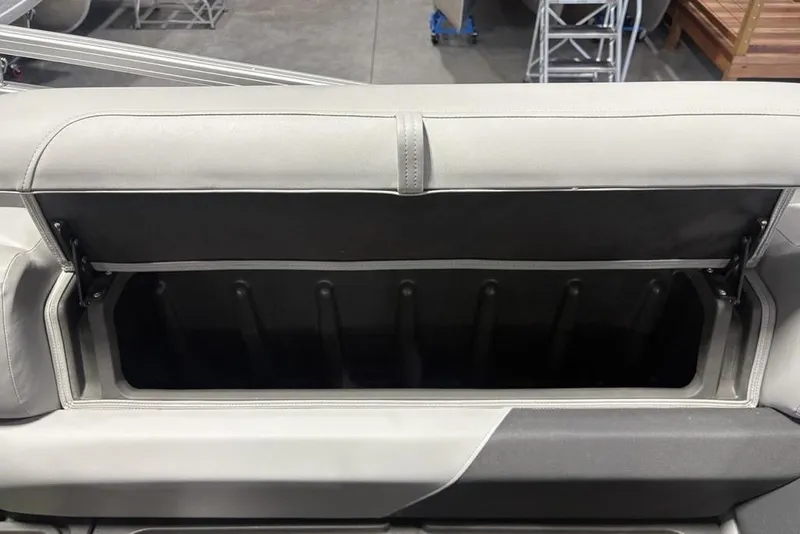 Slide: The Image of 2026 Sun Tracker PARTY BARGE® 20 DLX storage compartment with open lid, showcasing interior space. - 26