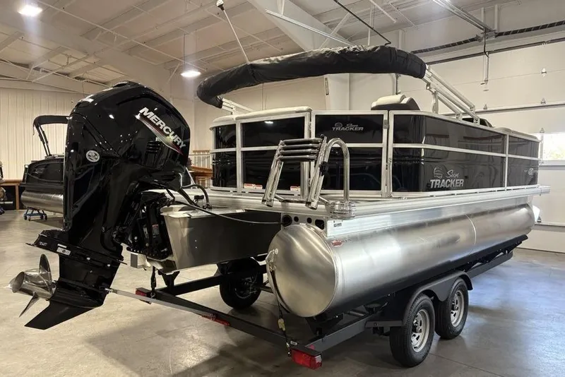 Slide: The Image of 2026 Sun Tracker PARTY BARGE® 20 DLX pontoon boat with Mercury outboard motor in a showroom. - 3