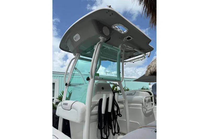 Slide: The Image of 2008 Everglades 243 Center Console boat with T-top and seating, under a blue sky. - 6