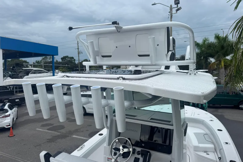 Slide: The Image of 2026 Blackfin 262 HB boat with rod holders and helm station, parked outdoors. - 11