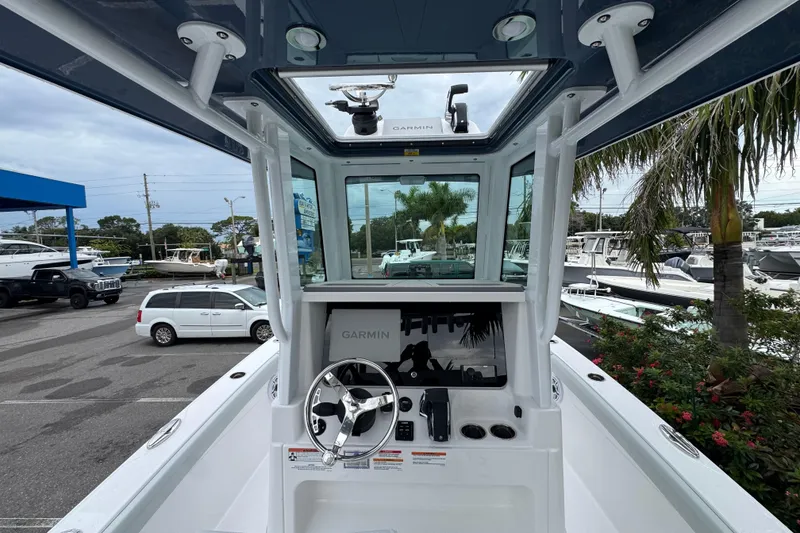 Slide: The Image of 2026 Blackfin 262 HB boat cockpit with Garmin navigation, parked near palm trees and vehicles. - 13