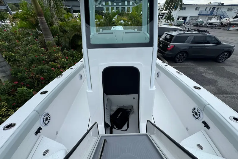 Slide: The Image of 2026 Blackfin 262 HB boat interior with open storage compartment, surrounded by lush greenery. - 33