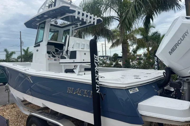 Slide: The Image of 2026 Blackfin 262 HB boat with Mercury engine, displayed outdoors near palm trees. - 5