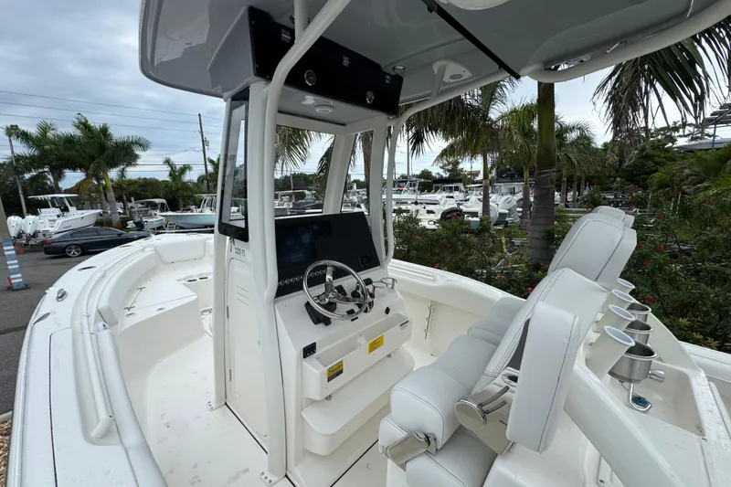 Slide: The Image of 2026 Key West 239 FS boat interior with helm, seating, and tropical background. - 14