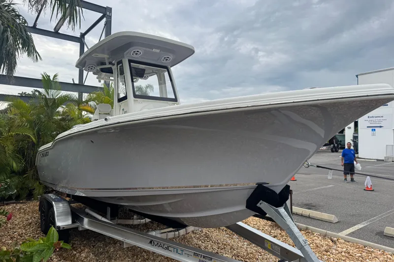 Slide: The Image of 2026 Key West 239 FS boat on trailer, parked outdoors near palm trees. - 4