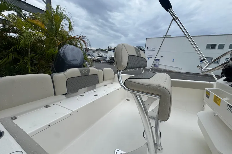 Slide: The Image of 2026 Key West 189 FS boat interior with seating and steering wheel, parked outdoors. - 10
