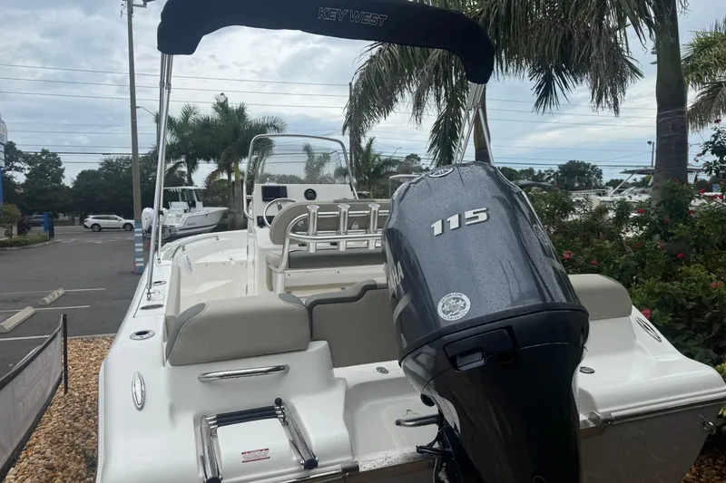Slide: The Image of 2026 Key West 189 FS boat with Yamaha 115 engine, parked near palm trees. - 3
