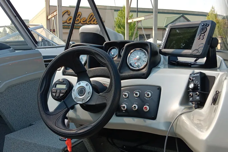 Slide: The Image of 2017 Tracker Pro Guide V-175 WT boat dashboard with steering wheel and navigation system. - 2