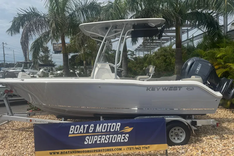 The Image of 2026 Key West 203 FS boat displayed at Boat & Motor Superstores, surrounded by palm trees. - 1