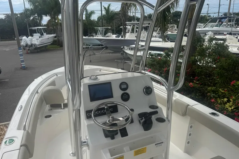 Slide: The Image of 2026 Key West 203 FS boat dashboard with steering wheel and gauges, surrounded by other boats. - 15