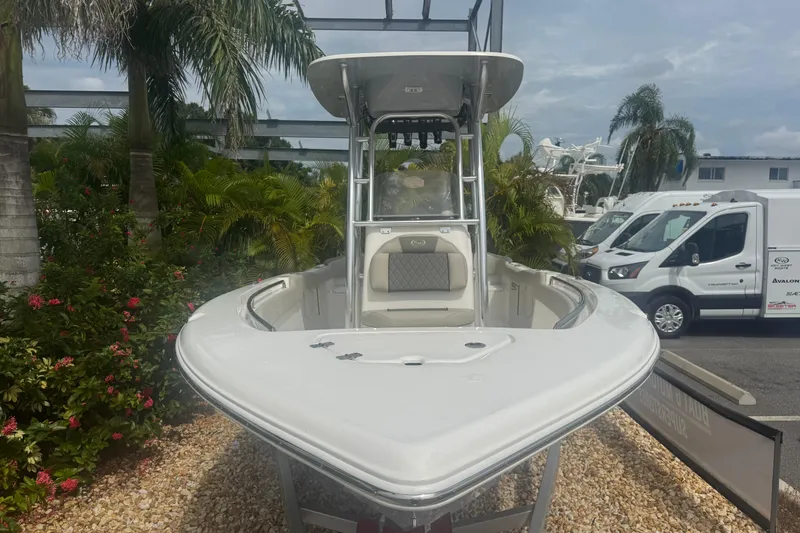 Slide: The Image of 2026 Key West 203 FS boat displayed outdoors with tropical plants and vehicles nearby. - 3