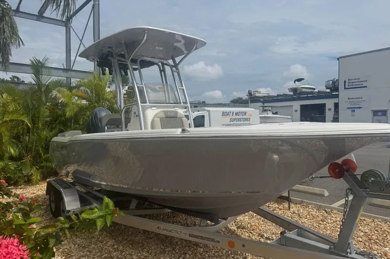 Slide: The Image of 2026 Key West 203 FS boat on trailer, parked near tropical plants and dealership. - 4