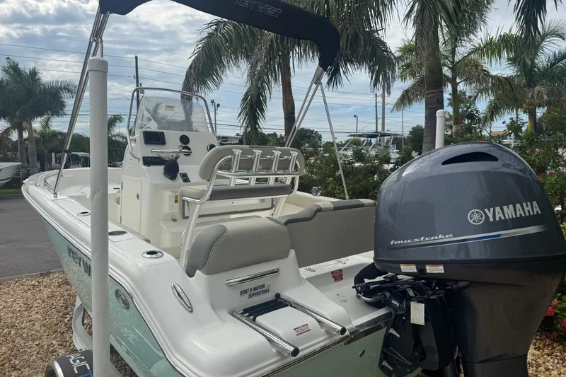 Slide: The Image of 2026 Key West 189 FS boat with Yamaha engine, parked near palm trees. - 12
