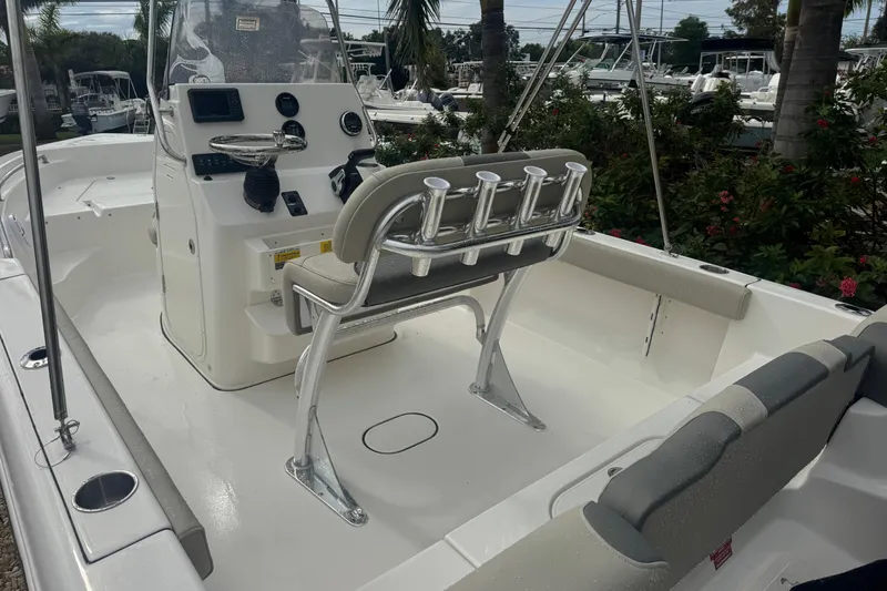 Slide: The Image of 2026 Key West 189 FS boat interior with console and seating, surrounded by greenery. - 13