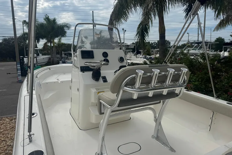 Slide: The Image of 2026 Key West 189 FS boat interior with console and seating, surrounded by palm trees. - 14