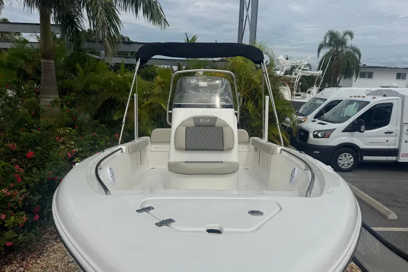 Slide: The Image of 2026 Key West 189 FS boat with seating, parked near tropical plants and vehicles. - 4