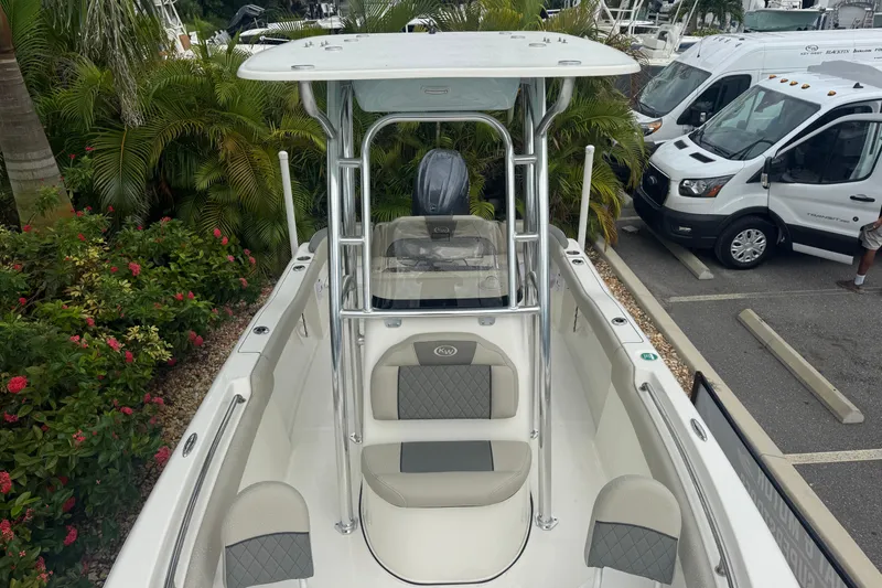 Slide: The Image of 2026 Key West 203 FS boat with seating, parked near tropical plants and vehicles. - 19
