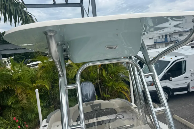 Slide: The Image of 2026 Key West 203 FS boat with T-top and stainless steel frame, parked near tropical foliage. - 22