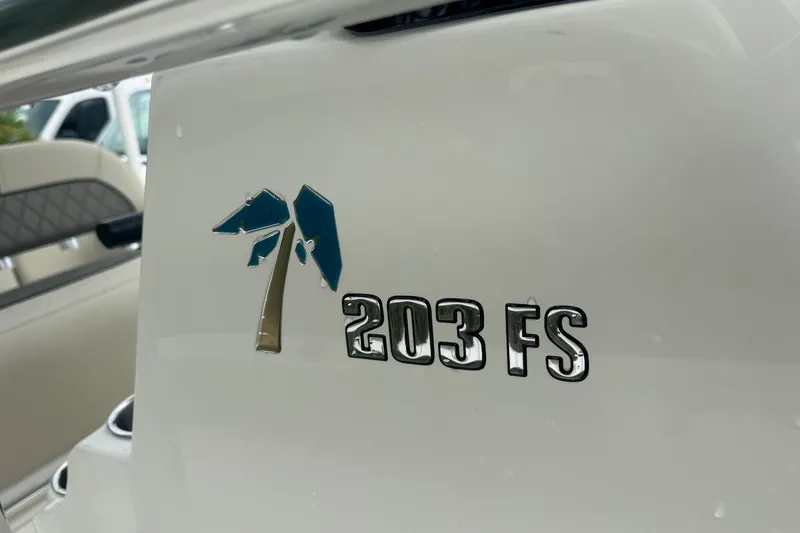Slide: The Image of 2026 Key West 203 FS boat logo on white surface, featuring a palm tree design. - 24