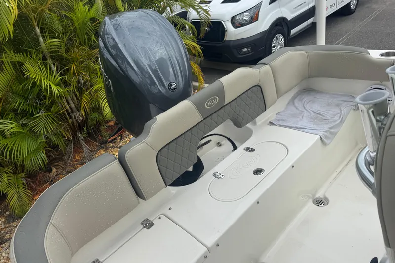 Slide: The Image of 2026 Key West 203 FS boat interior with Yamaha outboard motor, parked near tropical plants. - 27