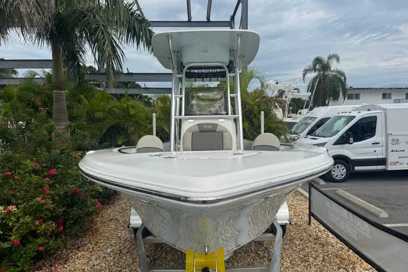 Slide: The Image of 2026 Key West 203 FS boat displayed outdoors with tropical plants and vehicles. - 3