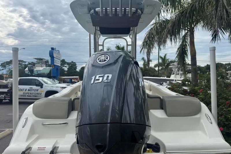 Slide: The Image of 2026 Key West 203 FS boat with Yamaha 150 engine, parked near palm trees. - 8