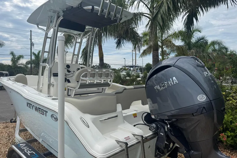 Slide: The Image of 2026 Key West 203 FS boat with Yamaha engine, parked near palm trees. - 9