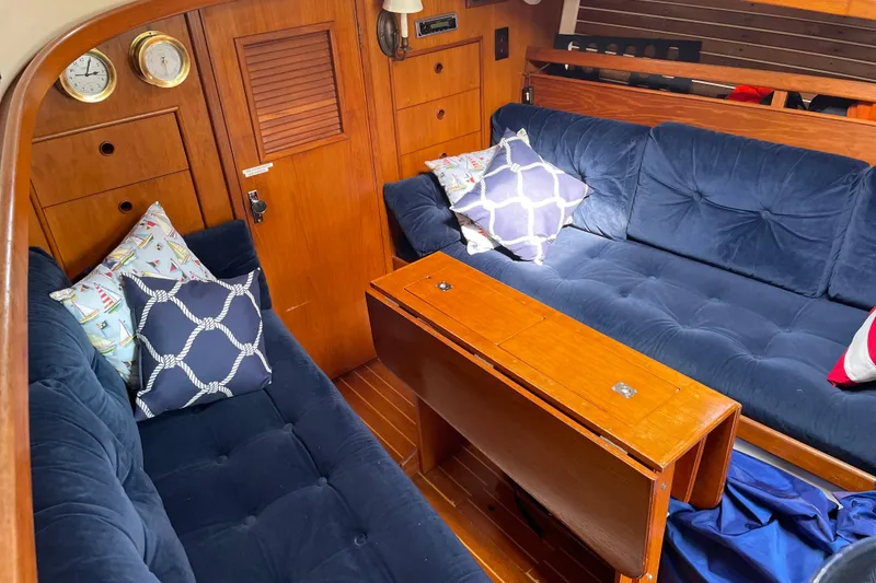 Slide: The Image of Interior of 1983 Nonsuch 30 Classic sailboat with blue cushioned seating and wooden accents. - 10