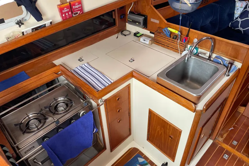 Slide: The Image of Compact galley kitchen in 1983 Nonsuch 30 Classic sailboat with stove and sink. - 12
