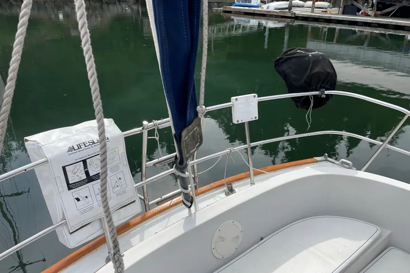 Slide: The Image of 1983 Nonsuch 30 Classic sailboat deck with safety equipment and railing. - 17