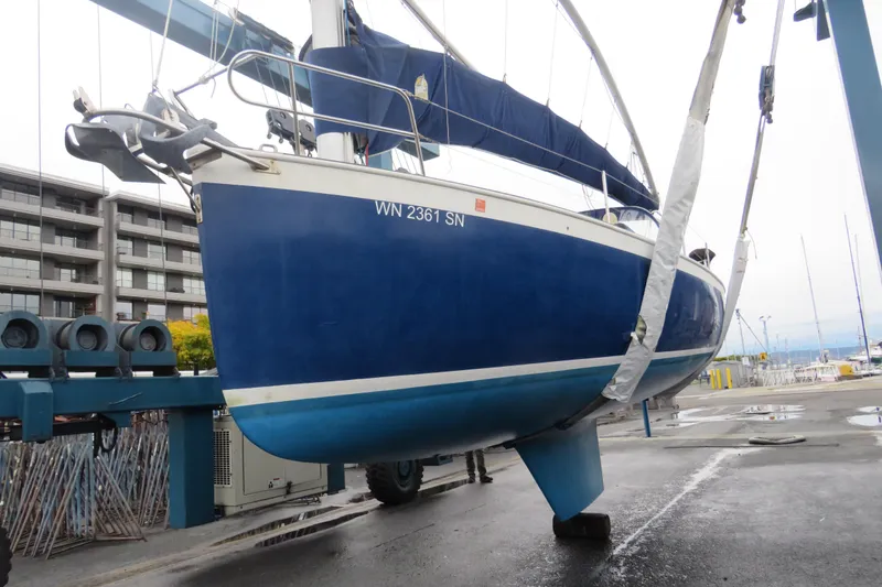 Slide: The Image of 1983 Nonsuch 30 Classic sailboat in dry dock, blue hull, marina background. - 21