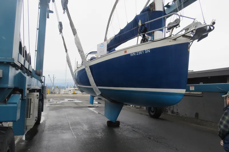 Slide: The Image of 1983 Nonsuch 30 Classic sailboat being lifted at a marina. - 24