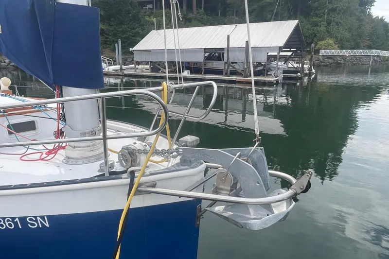 Slide: The Image of 1983 Nonsuch 30 Classic sailboat docked, featuring anchor and marina backdrop. - 4