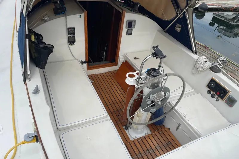Slide: The Image of Cockpit of 1983 Nonsuch 30 Classic sailboat with wooden flooring and steering wheel. - 8