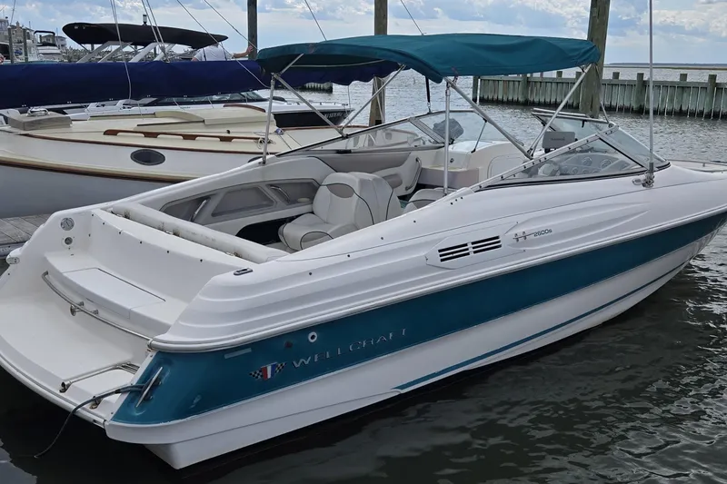 Slide: The Image of 1996 Wellcraft 2600s Eclipse Bowrider boat docked with blue canopy. - 13