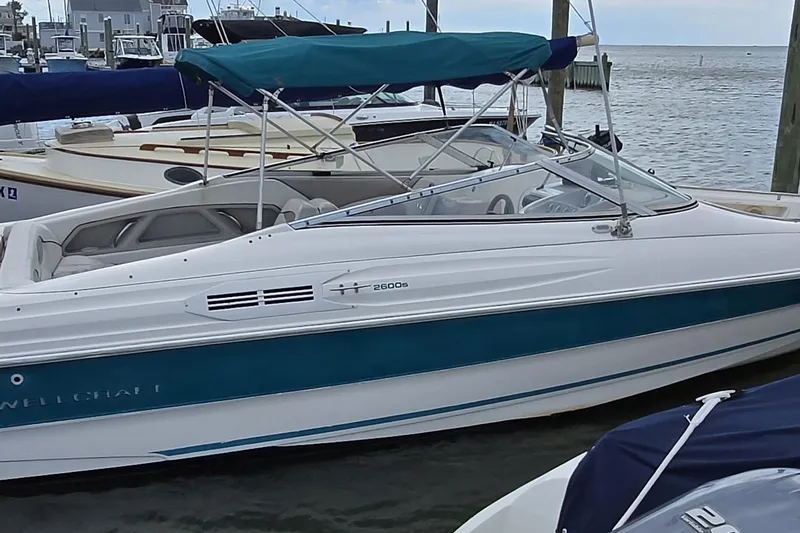 Slide: The Image of 1996 Wellcraft 2600s Eclipse Bowrider boat docked at marina with blue canopy. - 14