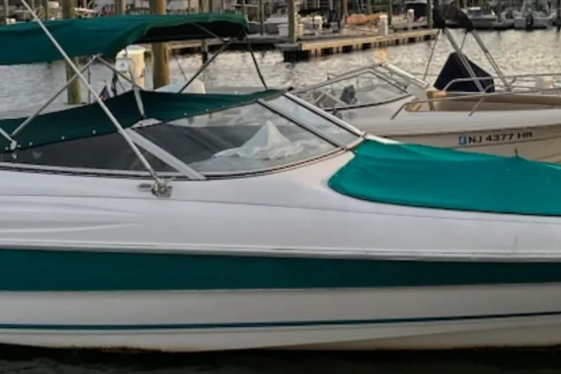 Slide: The Image of 1996 Wellcraft 2600s Eclipse Bowrider with green canopy docked at marina. - 7