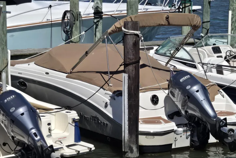 Slide: The Image of 2018 NauticStar 243DC Sport Deck boat docked with twin outboard engines. - 0
