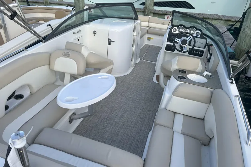 Slide: The Image of 2018 NauticStar 243DC Sport Deck boat interior with beige seating and steering console. - 1
