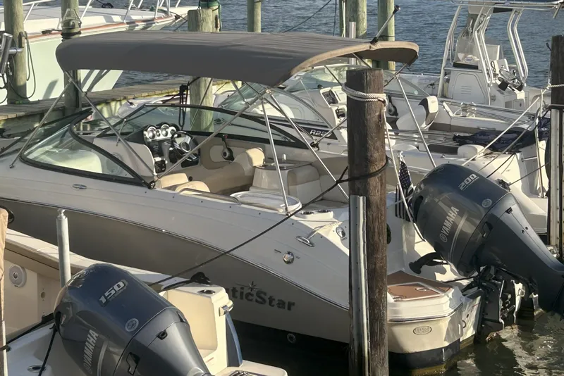 Slide: The Image of 2018 NauticStar 243DC Sport Deck boat docked with dual Yamaha outboard engines. - 14