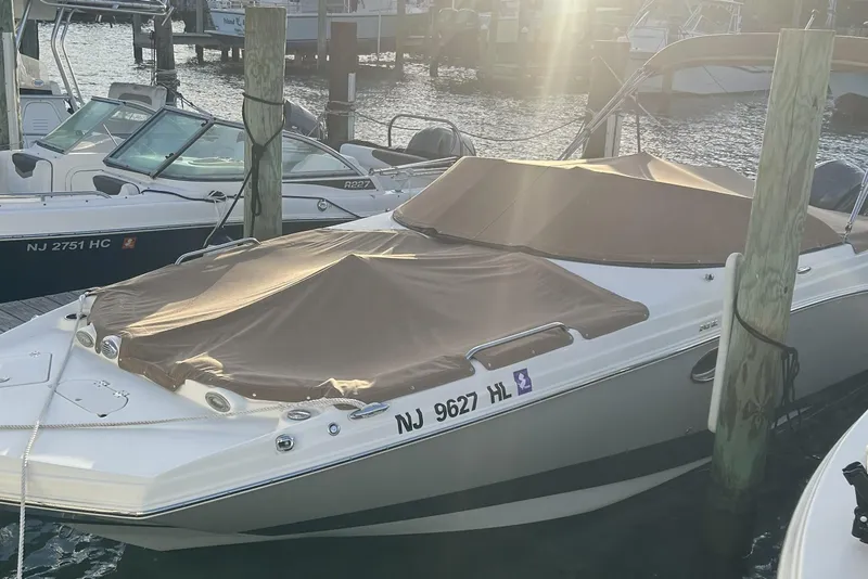Slide: The Image of 2018 NauticStar 243DC Sport Deck boat docked with cover in marina. - 15