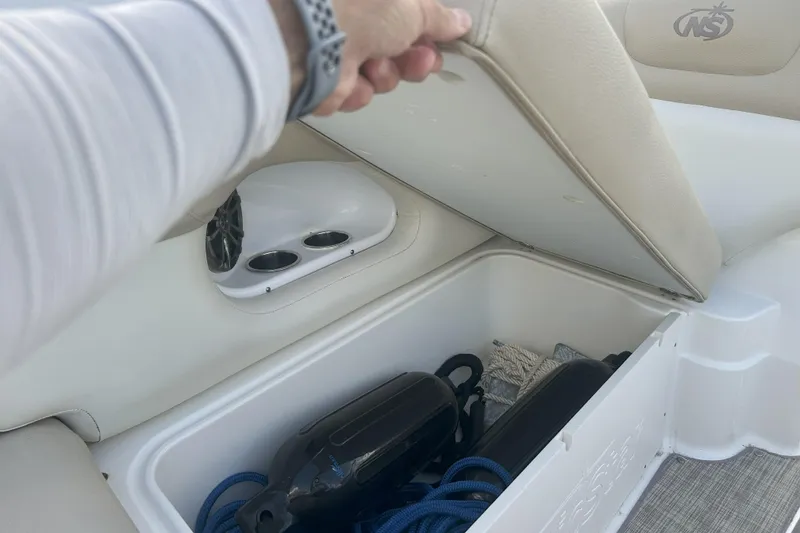 Slide: The Image of 2018 NauticStar 243DC Sport Deck storage compartment with marine equipment and accessories. - 16